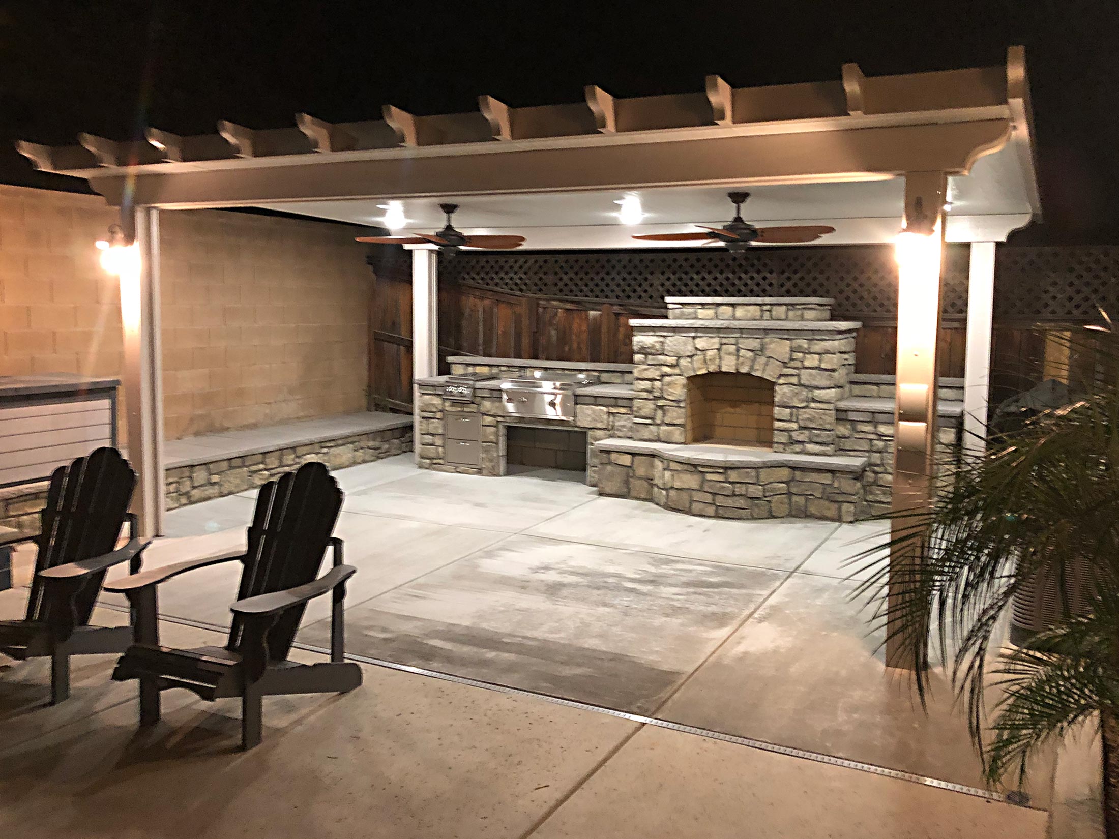 Custom outdoor living area and kitchen with fireplace by ProPatio by Weber Construction.