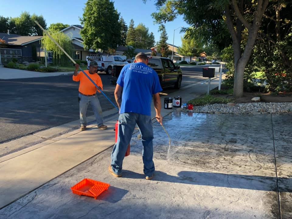 Mike spraying freshly poured stamped concrete.